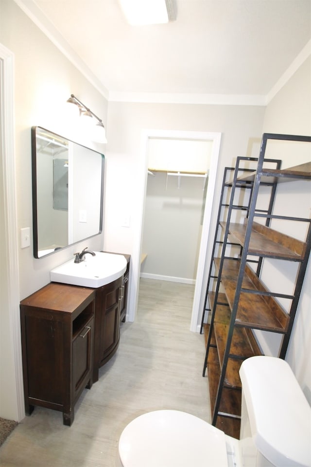 bathroom with crown molding, toilet, vanity, and hardwood / wood-style floors