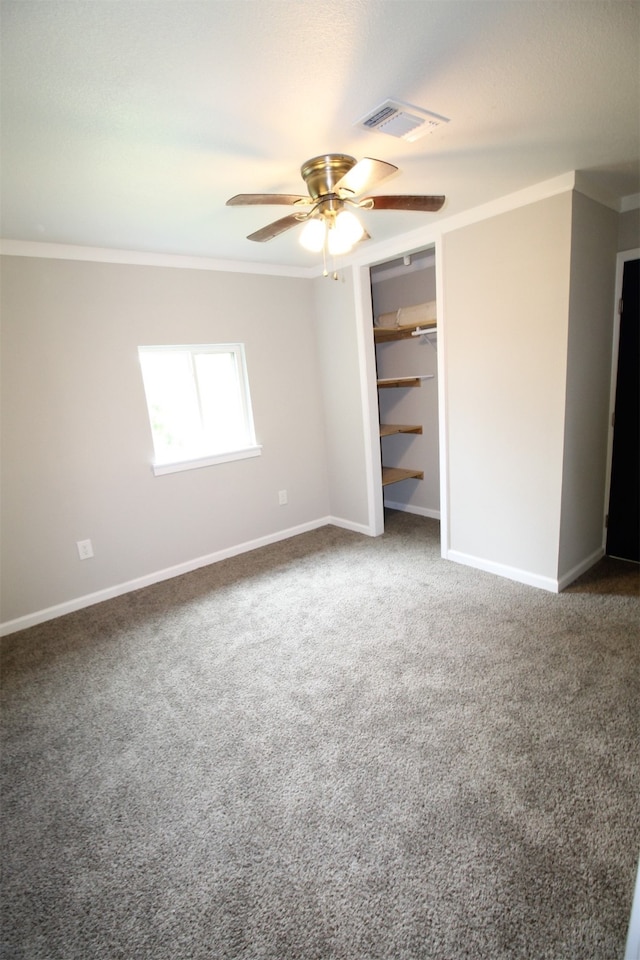 unfurnished bedroom with ornamental molding, ceiling fan, and carpet