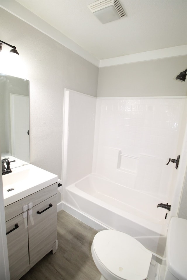 full bathroom featuring hardwood / wood-style flooring, shower / tub combination, vanity, and toilet