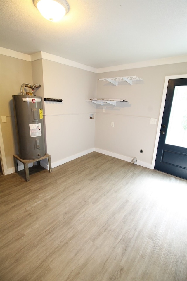 interior space featuring ornamental molding, light wood-type flooring, and electric water heater