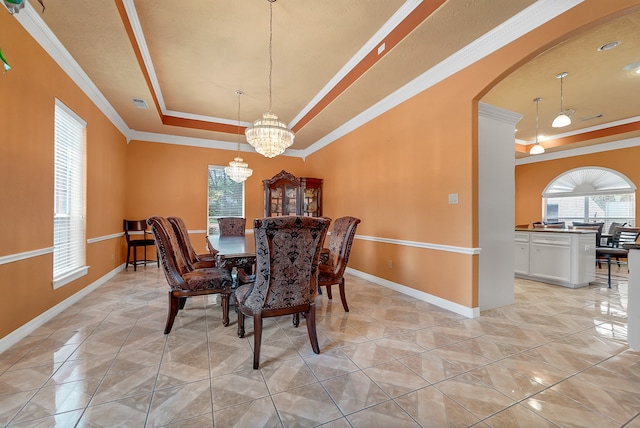 tiled dining area featuring a wealth of natural light, crown molding, a chandelier, and a tray ceiling