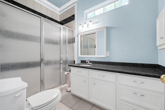 bathroom featuring oversized vanity, a shower with shower door, tile floors, and toilet