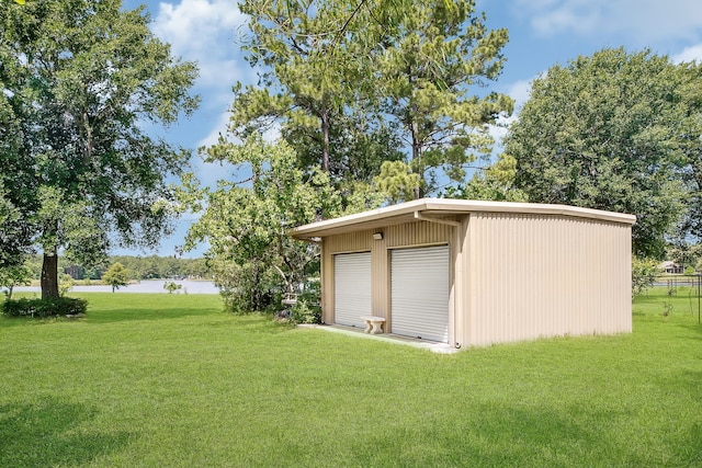 garage featuring a water view and a lawn