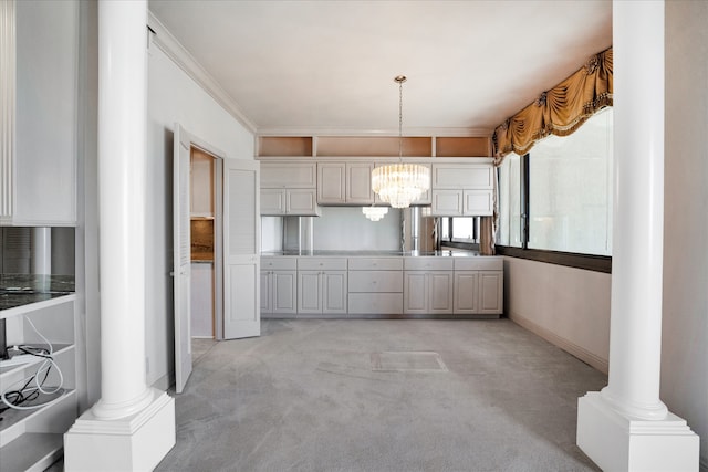 kitchen featuring ornate columns, ornamental molding, light carpet, and a chandelier