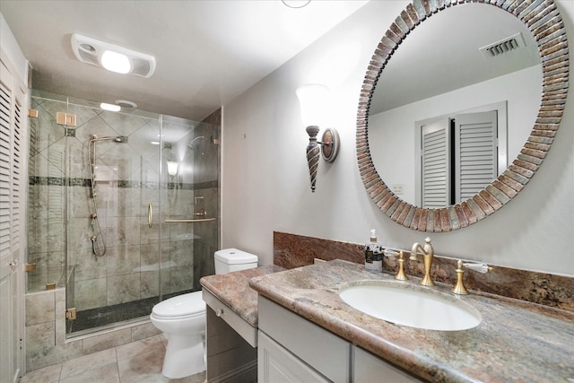 bathroom with vanity, a shower with shower door, tile patterned floors, and toilet