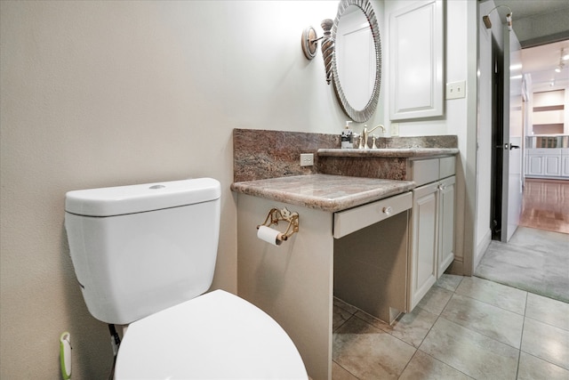 bathroom featuring vanity, tile patterned flooring, and toilet