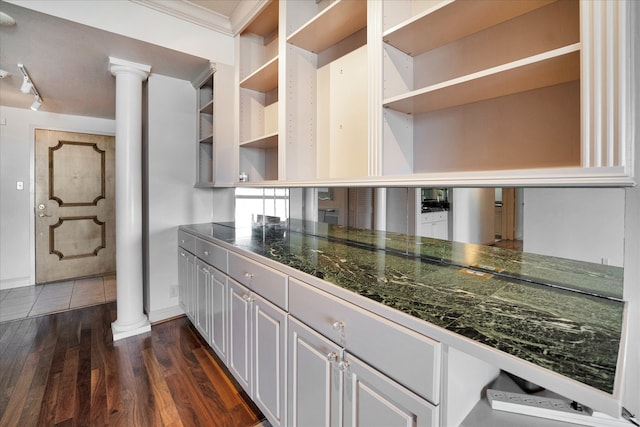 kitchen featuring dark hardwood / wood-style flooring, decorative columns, rail lighting, and white cabinets