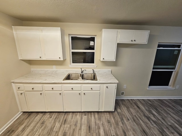 kitchen with dark hardwood / wood-style floors, sink, and white cabinetry