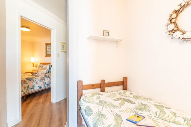 bedroom featuring light hardwood / wood-style flooring and ornamental molding