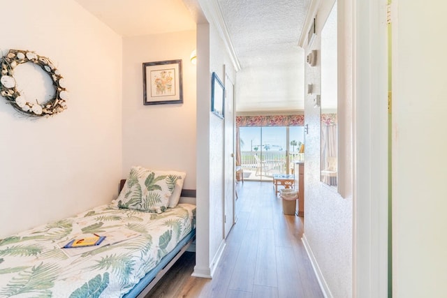 bedroom with light hardwood / wood-style flooring and a textured ceiling