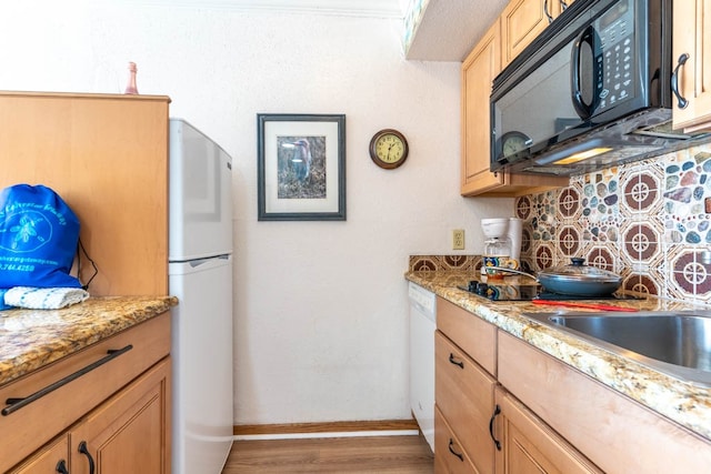 kitchen featuring wood-type flooring, white appliances, and light stone counters