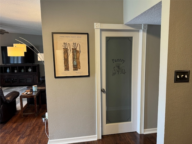 corridor featuring dark hardwood / wood-style flooring and a textured ceiling