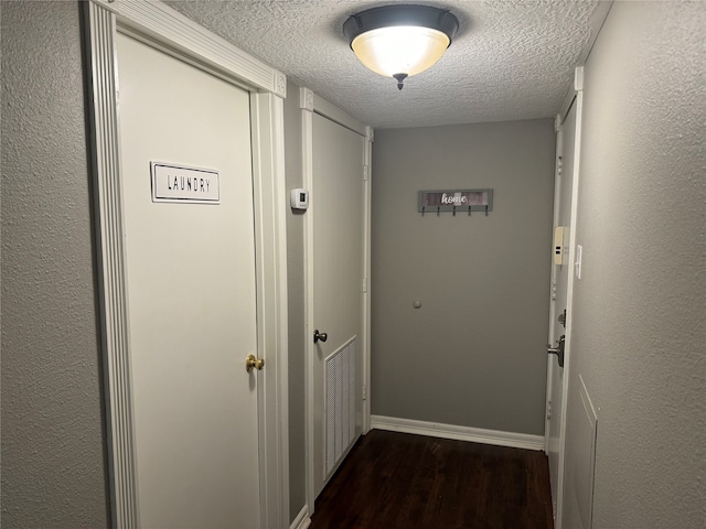 corridor featuring dark hardwood / wood-style flooring and a textured ceiling