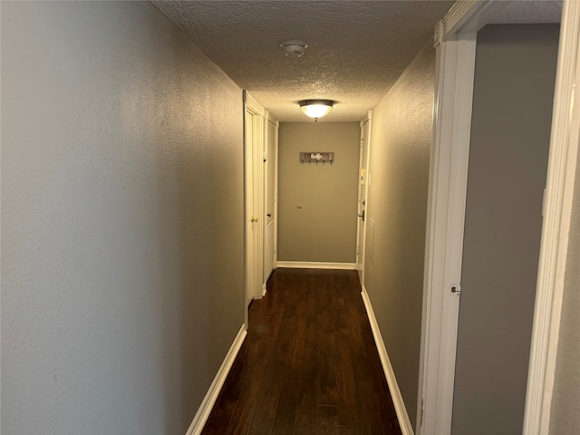 hall with dark hardwood / wood-style flooring and a textured ceiling