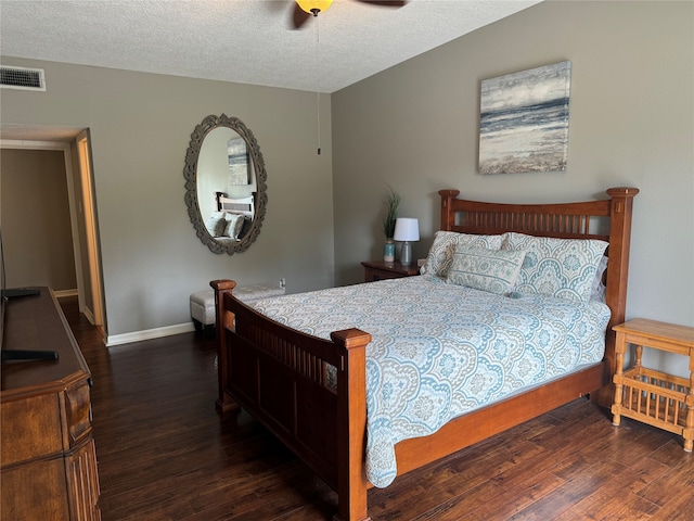 bedroom with dark hardwood / wood-style floors, ceiling fan, and a textured ceiling