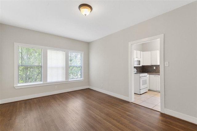 unfurnished room featuring light wood-type flooring and baseboards