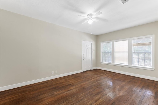 unfurnished room with ceiling fan, baseboards, and dark wood-type flooring