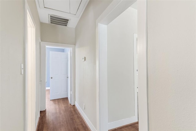 corridor with baseboards, dark wood-style flooring, visible vents, and attic access