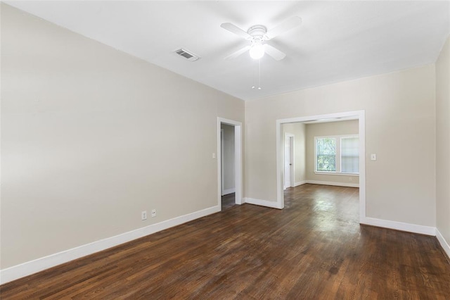 unfurnished room with a ceiling fan, baseboards, visible vents, and dark wood-style flooring