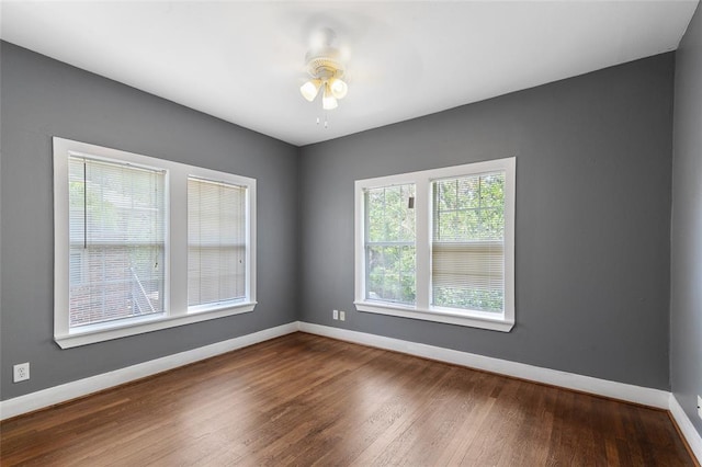 spare room featuring ceiling fan, baseboards, and wood finished floors