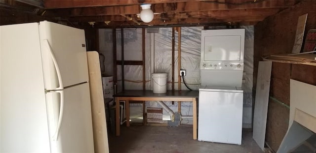 basement featuring white refrigerator and stacked washer / drying machine