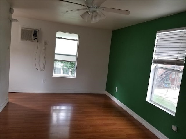 empty room featuring plenty of natural light, dark wood-type flooring, and ceiling fan