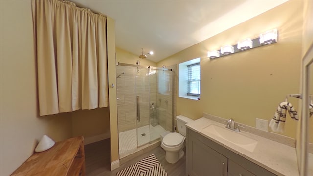 bathroom featuring a shower with door, toilet, vanity, and lofted ceiling