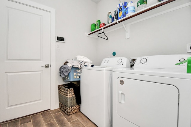 laundry room with washer and clothes dryer and dark wood-type flooring