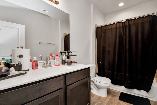 full bathroom with hardwood / wood-style floors, vanity, shower / tub combo, and toilet