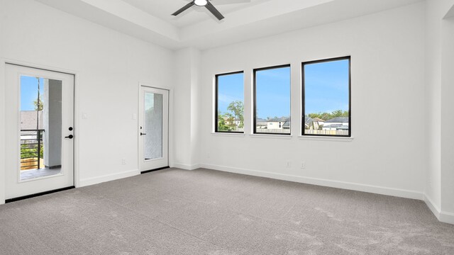 carpeted spare room with a wealth of natural light and ceiling fan