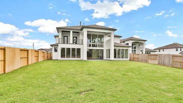 rear view of property featuring a lawn