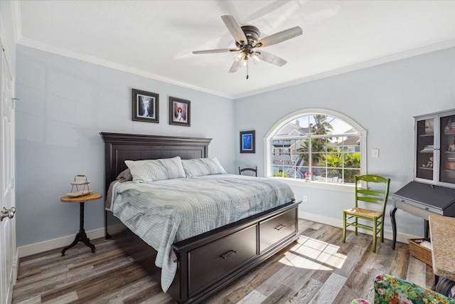 bedroom with ceiling fan, dark wood-type flooring, and crown molding