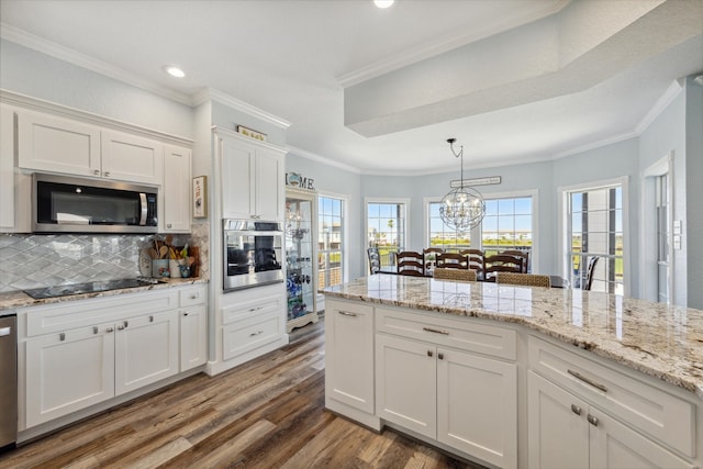 kitchen featuring appliances with stainless steel finishes, tasteful backsplash, crown molding, and white cabinets