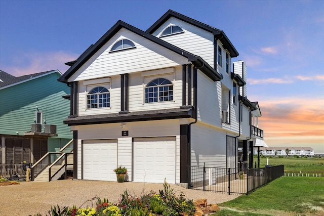 view of front of house featuring a garage, central AC unit, and a lawn