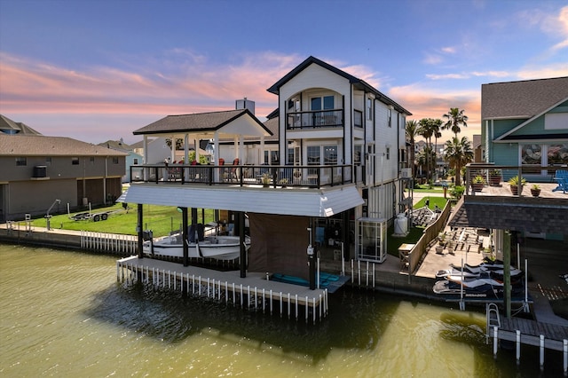 dock area with a water view and a balcony