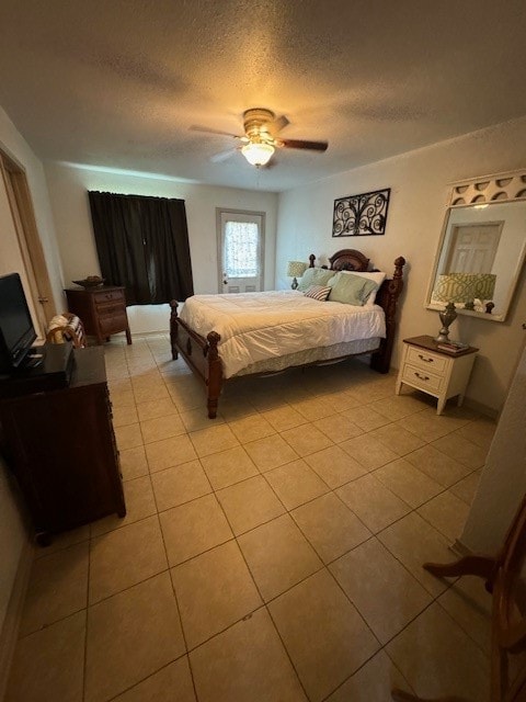 bedroom with a textured ceiling, ceiling fan, and light tile floors