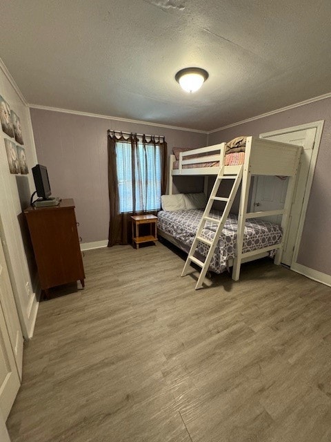 unfurnished bedroom with ornamental molding, light hardwood / wood-style floors, and a textured ceiling