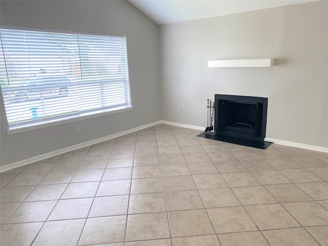 unfurnished living room featuring vaulted ceiling and light tile patterned flooring