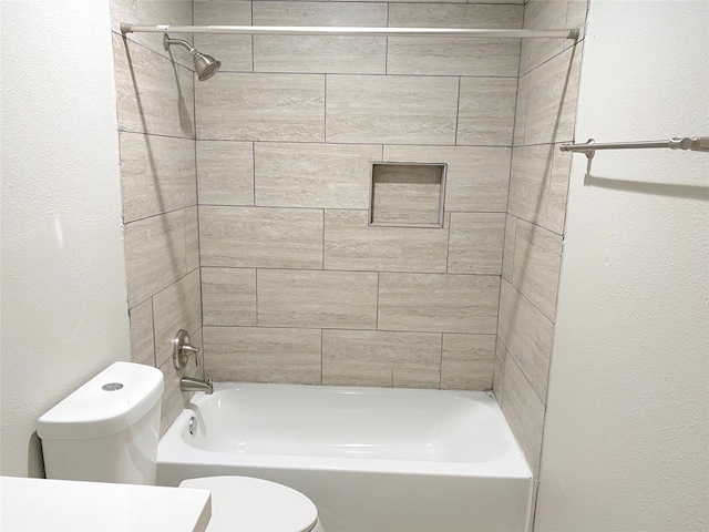 bathroom with toilet and tiled shower / bath