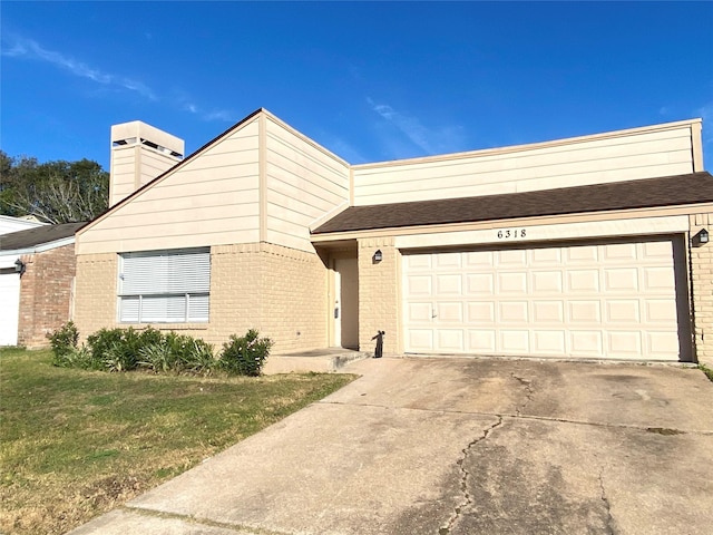 view of front of house with a front yard and a garage