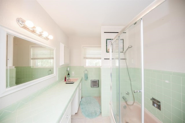 bathroom with tile walls, a wealth of natural light, and vanity