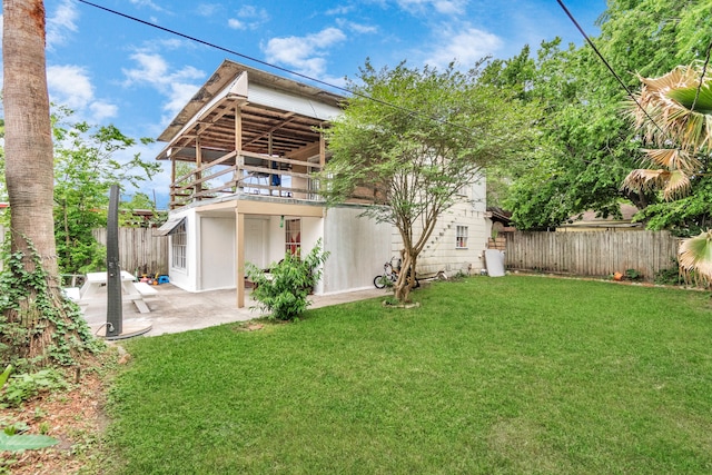 rear view of house featuring a patio area and a yard