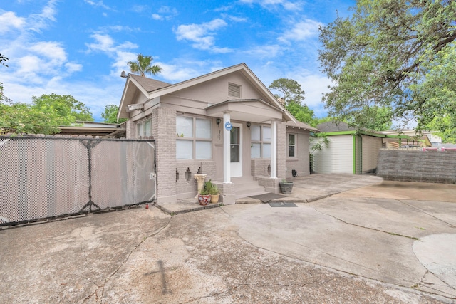 view of front of home featuring a patio area and an outdoor structure