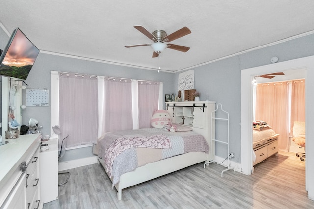 bedroom with crown molding, light hardwood / wood-style flooring, ceiling fan, and a textured ceiling