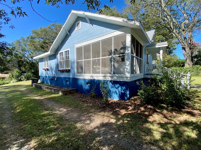 view of side of property featuring a yard and a sunroom