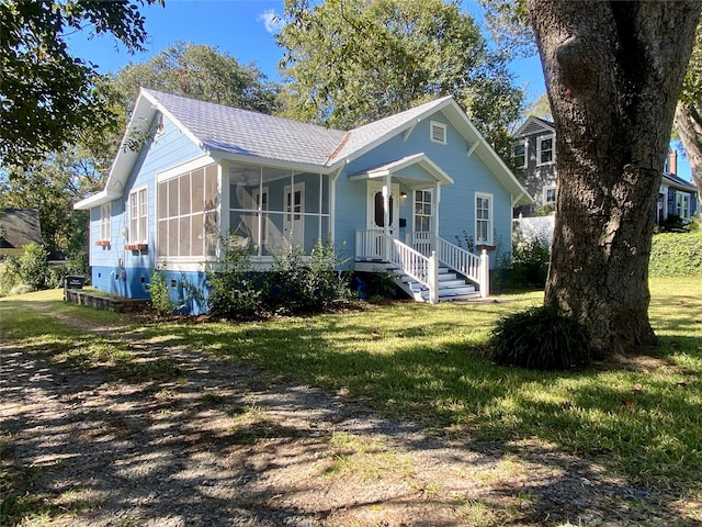 view of front of property with a front lawn and a sunroom