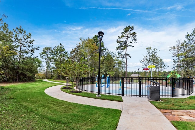 view of home's community with a pool and a yard