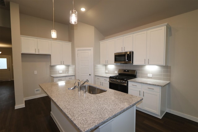 kitchen featuring white cabinetry, stainless steel appliances, a kitchen island with sink, hanging light fixtures, and sink