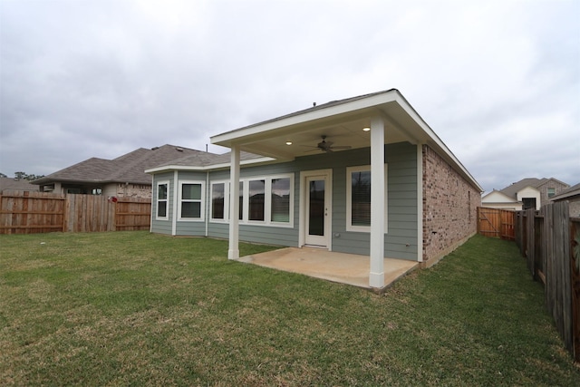 rear view of property featuring ceiling fan, a lawn, and a patio