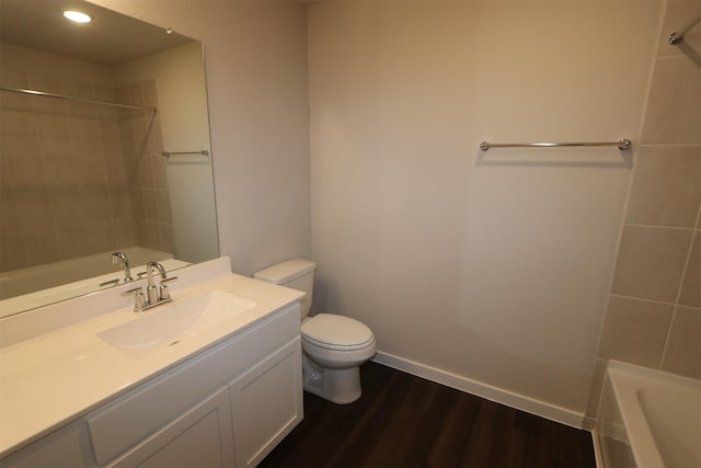 full bathroom with hardwood / wood-style flooring, toilet, vanity, and tiled shower / bath